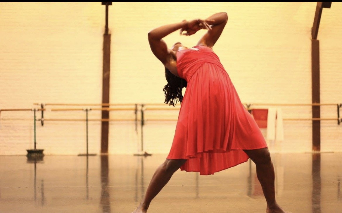 Danseuse en robe rouge cambrée en arrière dans un studio de danse, la formation Mouvement Essentiel