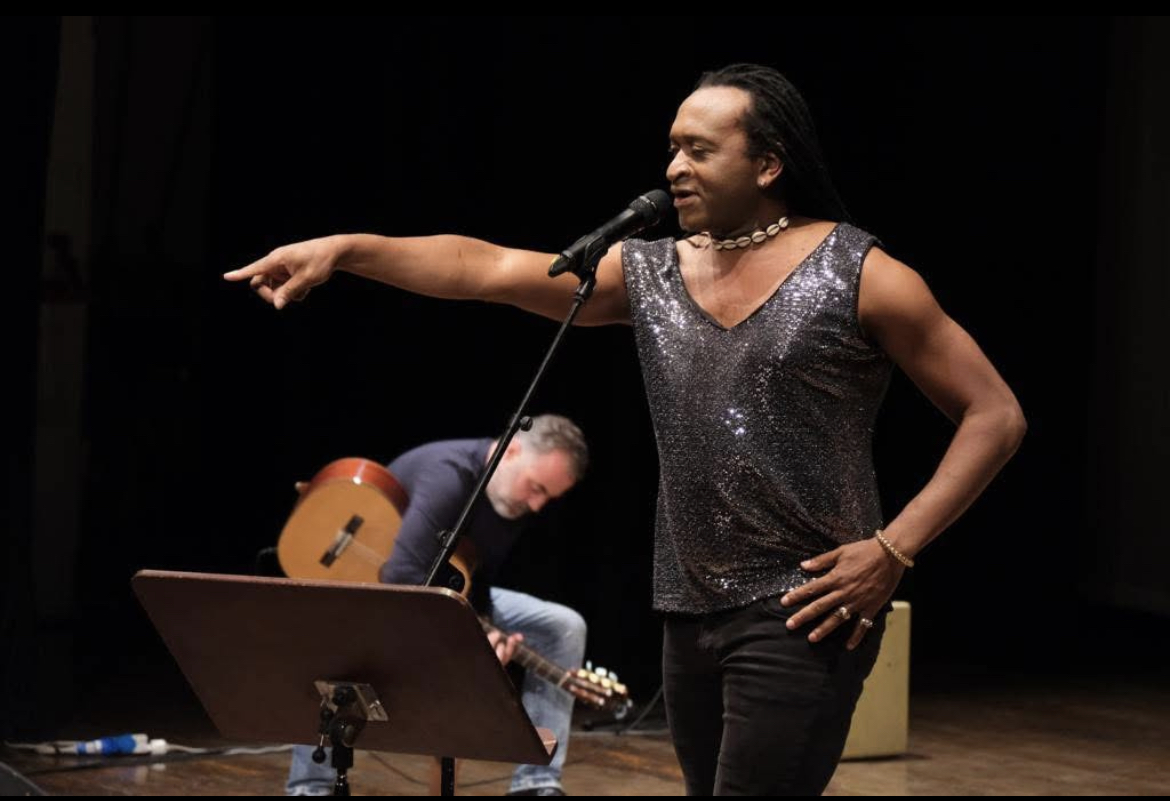 Zam Martino chantant sur scène accompagné d’un guitariste